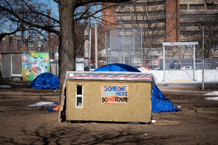 A photo of a shelter in Toronto's Alexandra Park from an April 16, 2021 New York Times story by Catherine Porter about carpenter Khaleel Seivwright, who built small life-saving shelters for unhoused people living outside in Toronto during the first winter of the pandemic. Seivwright's story is told in Zac Russell's award-winning documentary "Someone Lives Here", which is screening on September 8, 2023 at Artspace in Peterborough as part of ReFrame Film Festival's free Mission Miniseries presented by the Peterborough Downtown Business Improvement Area. (Photo: Ian Willms for The New York Times)