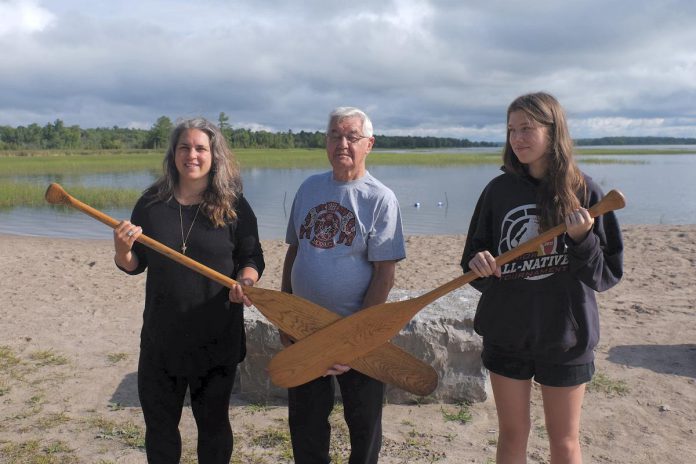 Curve Lake First Nation Chief Keith Knott (middle) with Dorianna Chessa (left), a land-based educator with the Gulf Islands School District in British Columbia who brought one of her former students with Ojibwe ancestry (right) to participate in Rotary Club of Peterborough Kawartha's eighth annual Adventure In Understanding trip. Chessa also brought two paddles she purchased in B.C. that were carved by someone from Curve Lake First Nation. (Photo courtesy of Dorianna Chessa)