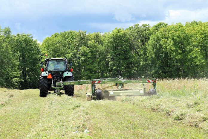 James Harley, co-owner of Harley Farms in Keene, cuts hay. While the agriculture sector is highly vulnerable to the impacts of climate change, it also produces 10 per cent of Canada's greenhouse gas emissions, not including the use of fossil fuels. The Net Zero Farms pilot project will subsidize a cohort of local agriculture businesses to join Green Economy Peterborough, where they will be supported to measure their footprint, learn from one another, and expand our regional understanding of local opportunities for climate action. (Photo: Veronica Price Jones / Harley Farms)
