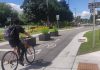 The Bethune Street bikeway, stretching from McDonnel Street to Townsend Street, is the first street in the City of Peterborough that best serves cyclists and pedestrians over cars and trucks. Pictured is a cyclist using Bethune Street while, in the background, an elderly couple walks beside a newly built pollinator garden. (Photo: Tegan Moss / GreenUP)