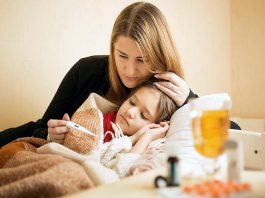 A mother taking the temperature of a sick child. (Stock photo)