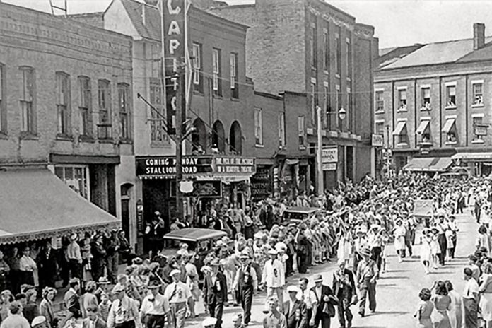 The Orange order walks past the Capitol Theatre in Port Hope on July 12, 1947, with the theatre's marquee promoting the 1947 Western film "Stallion Road" starring future U.S. president Ronald Reagan. (Photo via porthopehistory.com)