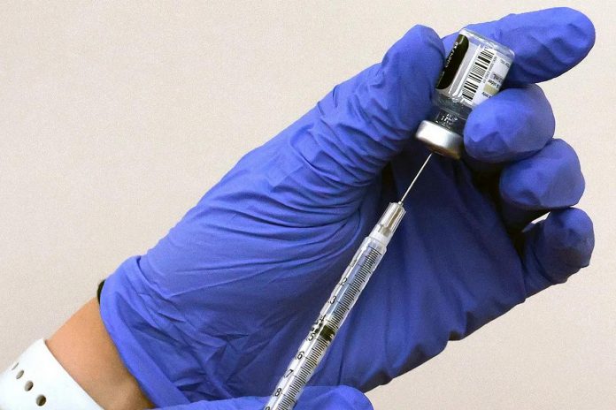 A pharmacist prepares to administer a shot of Comirnaty, the updated Pfizer-BioNTech vaccine for COVID-19 that targets the new omicron XBB subvariant, in Orlando, Florida, on September 14, 2023. (Photo: Joe Burbank / Orlando Sentinel / The Associated Press)