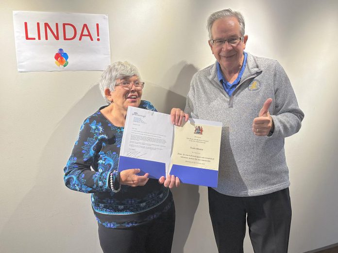 Peterborough Mayor Jeff Leal presented longtime volunteer Linda Shisko with a letter and certificate from the City of Peterborough recognizing her 30 years of volunteer service to the community at the Market Hall in Peterborough on October 20, 2023. Linda, who has provided weekly cleaning services for at least a dozen non-profit agencies since 1996, is retiring in advance of her 73rd birthday. (Photo: Eva Fisher / Public Energy Performing Arts)