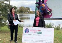 Peterborough's Dragon Boat Festival chair Michelle Thornton (right) presents a $290,025.18 cheque to Lesley Heighway, president and CEO of the Peterborough Regional Health Centre Foundation, on October 11, 2023 at the T-wharf on Little Lake, the site of the annual festival. Proceeds from this year's festival will allow the regional hospital to invest in new state-of-the-art technology to serve more cancer patients, support earlier cancer diagnosis, and provide safer and more effective treatments. (kawarthaNOW screenshot of Peterborough's Dragon Boat Festival video)