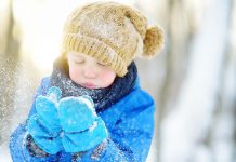 A young boy wearing a hat and mittens in the winter. (Stock photo)