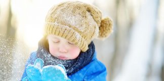 A young boy wearing a hat and mittens in the winter. (Stock photo)