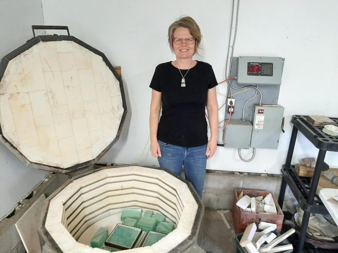 Artist Christy Haldane in her studio in Douro, which she shares with Garrett Gilbart of Burn Island. Haldane fuses recycled glass with building materials and resources including concrete, stone, and steel, to create functional and sculptural pieces including vases, pendants, book ends, and her custom "memory stones."  (Photo courtesy of Christy Haldane)