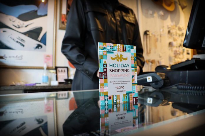 Holiday Shopping Passports are now available at over 140 participating shops, boutiques, salons, restaurants, and cafes in downtown Peterborough. Each completed passport becomes a ballot for one of three early bird draws on Wednesdays during December for a $500 Boro gift card and a grand prize draw for a $1,500 Boro gift card in January. (Photo courtesy of Peterborough Downtown Business Improvement Area)