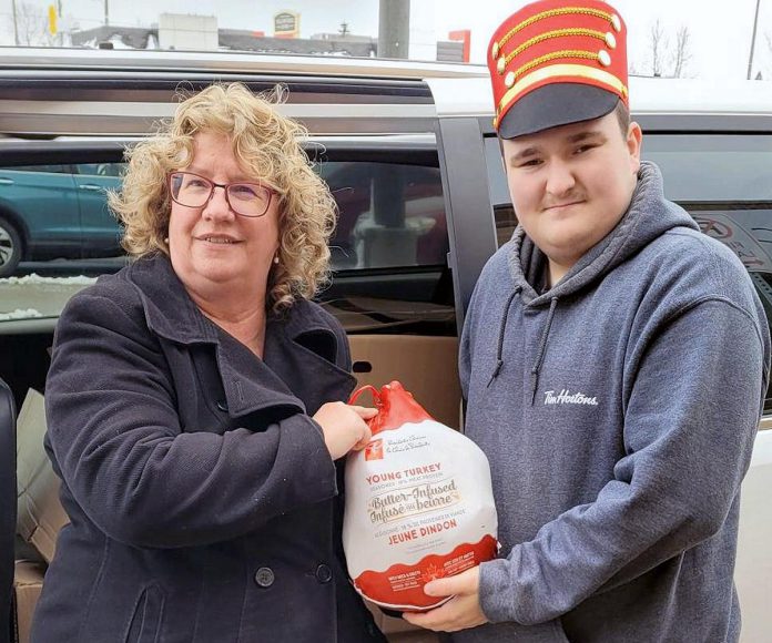 Lions Theresa Hewitt and Lucas with a donated turkey during the Great Turkey Exchange in 2022, when the East Peterborough Lions Club took over the long-running program. As well as delivering turkeys and hams to individuals and families in need, the Lions distributed them to organizations including One Roof, YES Shelter for Youth and Families, the Brock Mission, and the YWCA Crossroads Shelter. (Photo: East Peterborough Lions Club / Facebook)