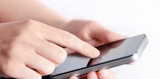 Fingers touching a mobile phone. (Stock photo)