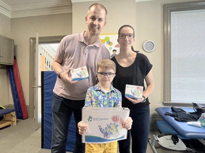 Six-year-old Gordon is joined by his parents Len and Sarah in displaying his artwork that graces the cover of Five Counties' new "thank you" cards given to its donors, volunteers, and supporters. Gord, who was born with a rare genetic condition called Aarskog-Scott syndrome, was assessed at Five Counties to see what supports he needed and subsequently received assistance from an occupational therapist and physiotherapist. (Photo courtesy of Five Counties)