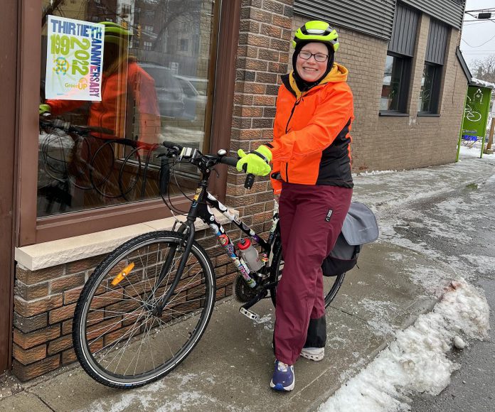 Eileen Kimmett, coordinator of the GreenUP Store & Resource Centre, stands in full winter cycling gear with her bike after a five-kilometre commute in 2022 from her home to the GreenUP Store in downtown Peterborough. (Photo: GreenUP)