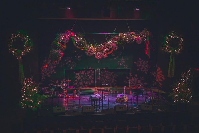 For many years, Dayle Finlay has designed the stage at Market Hall Performing Arts Centre for the annual In From The Cold benefit concert for Peterborough's YES Shelter for Youth and Families, featuring natural greenery, a glowing grapevine garland, and over a thousand twinkling lights. In From The Cold returns for its 24th year on December 8 and 9, 2023 at Market Hall Performing Arts Centre. (Photo courtesy of In From The Cold)