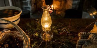 Lang Pioneer Village Museum in Keene will be lit by the warm glow of candles, lamps, and lanterns and decorated with pine and cedar garlands and freshly made natural centerpieces during 'Christmas by Candlelight' on December 2 and 3, 2023. The event features horse-drawn wagon rides, live music, historical stories, readings, games, visits with Santa, photos in a winter sleigh, and more. (Photo: Heather Doughty Photography)