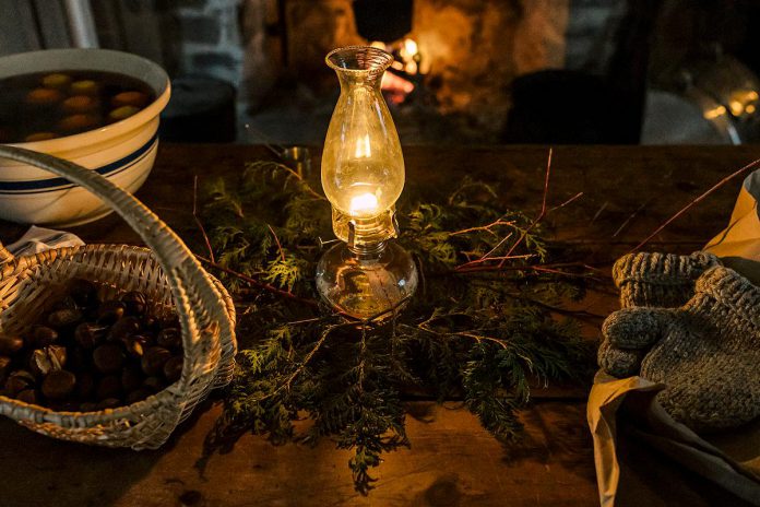 Lang Pioneer Village Museum in Keene will be lit by the warm glow of candles, lamps, and lanterns and decorated with pine and cedar garlands and freshly made natural centerpieces during 'Christmas by Candlelight' on December 2 and 3, 2023. The event features horse-drawn wagon rides, live music, historical stories, readings, games, visits with Santa, photos in a winter sleigh, and more. (Photo: Heather Doughty Photography)