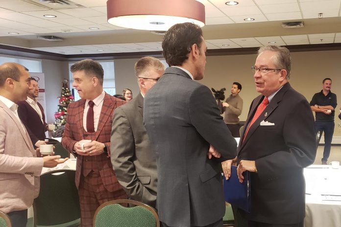 Peterborough Mayor Jeff Leal (right) speaks with VIA HFR CEO Martin Imbleau (back to camera) prior to both men delivering remarks during the annual Mayor's Breakfast at the Peterborough Golf Country and Club on November 21, 2023 hosted by the Peterborough and the Kawarthas Chamber of Commerce. (Photo: Jeannine Taylor / kawarthaNOW)