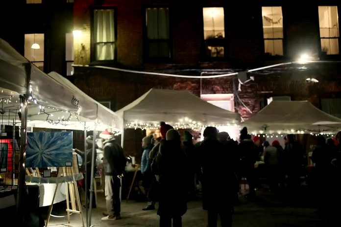 The Commerce Building Courtyard in downtown Peterborough will be transformed into a festive market on December 1, 2023 for the Neighbourhood Holiday Market organized by The Neighbourhood Vintage in partnership with First Friday Peterborough. The evening event during the First Friday art crawl features work from 20 local artists and artisans, live music performances, and food and drink. Pictured is the December 2022 market. (kawarthaNOW screenshot of First Friday Peterborough video)