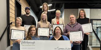 Business Advisory Centre manager Madeleine Hurrell (top of stairs) overlooks the Peterborough-area entrepreneurs whose eight businesses were awarded a collective $39,000 in grants from the fall 2023 intake of the provincially funded Starter Company Plus program administered by Peterborough & the Kawarthas Economic Development. Sara Scheuermann of Steaped Slow Ceramics and Jordan Lyall of Jordan Lyall Photography are holding the cheque and, behind them, left to right, are Iola Taylor of Cold Duck Creamery, Cody Lewis of Cody Lewis Carpentry, Mackenzie Caldwell of Grace & Glow Beauty Studio, Meaghan Kynock of muttmix, Joe Crowley of Crowley Acres, and Katie Jackson of Wanderlight Luxury Farm Stay. (Photo courtesy of Peterborough & the Kawarthas Economic Development)