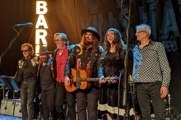Juno award-nominated singer-songwriter and guitarist Terra Lightfoot with Blackie and the Rodeo Kings (left to right: Gary Craig, Colin Linden, Stephen Fearing, Tom Wilson, and John Dymond) enjoying a standing ovation from the audience after a December 7, 2022 concert at Market Hall Performing Centre in downtown Peterborough. (Photo: Bruce Head)