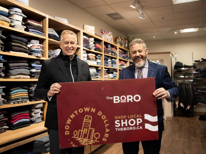 Holiday Shopping Passport early bird winner Tony Jeffery (left) celebrates his win with Andrew Damiany, owner of Gentry Apparel at 377 George Street North, where Jeffery completed his winning passport. (Photo courtesy of Peterborough DBIA)