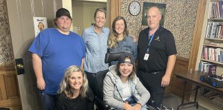 Fifteen-year-old Kaydance (in wheelchair) stops by Five Counties' Seating and Mobility Clinic with her mom April (standing, second from right) to get her chair adjusted. Also pictured are (standing, from left) Five Counties technician Luke, occupational therapist Kate Jaboor, and seating and mobility consultant Stewart from Motion Peterborough. Crouched beside Kaydance is Five Counties physiotherapist Ange Harrison. (Photo courtesy of Five Counties Children's Centre)