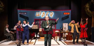 For New Stages Peterborough's production of "It's a Wonderful Life: A Live Radio Play," the stage at Market Hall Performing Arts Centre is transformed into a radio station in Bedford Falls on Christmas Eve in 1946, set to air a radio version of the classic Christmas film to millions of people before a live "studio" audience. Pictured from left to right are musical director and pianist Gabriel Vaillant and actors Megan Murphy, M. John Kennedy, Kerry Griffin, Brad Brackenridge, and Ordena Stephens-Thompson, who perform all the characters from the movie and also create all of the sound effects. (Photo: Dahlia Katz)