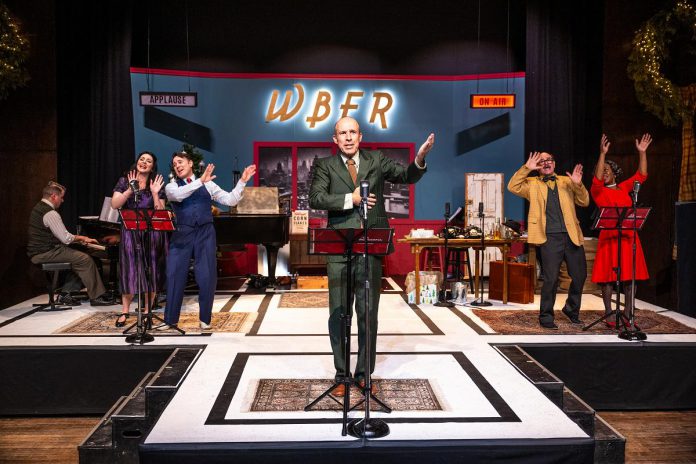 For New Stages Peterborough's production of "It's a Wonderful Life: A Live Radio Play," the stage at Market Hall Performing Arts Centre is transformed into a radio station in Bedford Falls on Christmas Eve in 1946, set to air a radio version of the classic Christmas film to millions of people before a live "studio" audience. Pictured from left to right are musical director and pianist Gabriel Vaillant and actors Megan Murphy, M. John Kennedy, Kerry Griffin, Brad Brackenridge, and Ordena Stephens-Thompson, who perform all the characters from the movie and also create all of the sound effects. (Photo: Dahlia Katz)