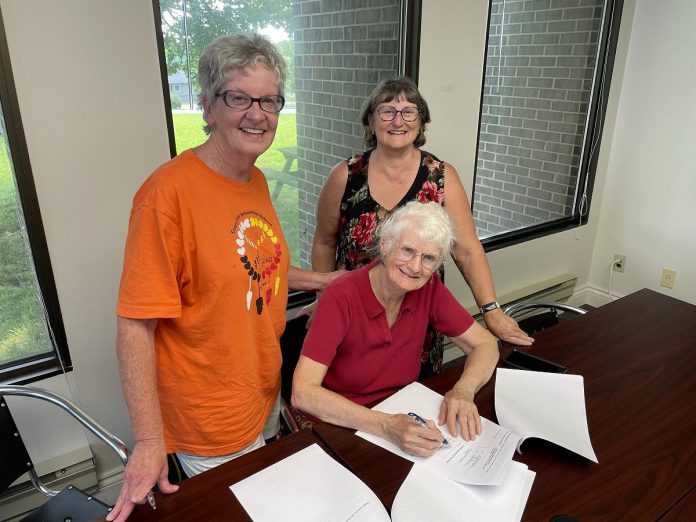 On August 2, 2023, representatives of Peterborough Action for Tiny Homes (PATH) met with Susan Zambonin of Habitat for Humanity Peterborough & Kawartha Region (back right) for the official signing of the lease agreement between Habitat for Humanity and PATH for the former site of the Peterborough Humane Society at 385 Lansdowne Street. The site will eventually house 30 sleeping cabins for unsheltered people. (Photo courtesy of PATH)