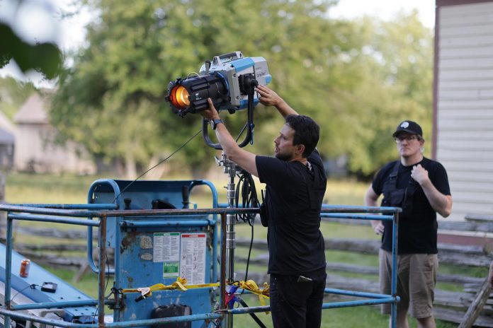"Grist" director of photography and co-director Pawel Dwulit adjusts a Arri Orbiter light on a 85-foot crane before it is raised up, as first assistant camera Jonathan Miller looks on, during the production of the proof-of-concept mini-series at Lang Pioneer Village in Keene in August 2023. Dwulit, a cinematographer and owner of Peterborough-based production company Paradigm Pictures, believes that with recent shifts in film towards narrative storytelling, there is great potential for Peterborough and the Kawarthas to be marketed for film production. (Photo: Adam Martignetti)