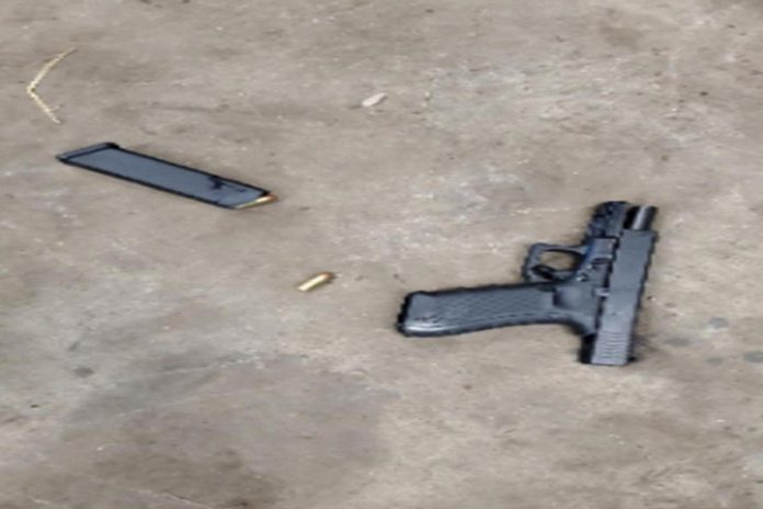 A witness took this cell phone photograph of the man's pistol on the floor of the service garage at the Peterborough Volkswagen dealership. (Photo via SIU report)