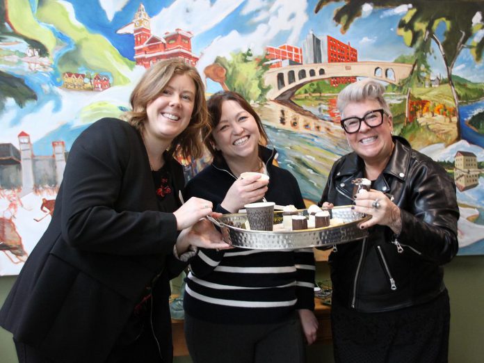 The Peterborough Downtown Business Improvement Area (DBIA) has announced the second annual Ptbo Hot Chocolate Fest will take place during the month of February, featuring 19 over-the-top hot chocolate creations from downtown Peterborough's most creative chocolatiers, pastry shops, bakeries, cafes and restaurants. Pictured are Peterborough & the Kawarthas Business Advisory Centre manager and DBIA board member Madeline Hurrell, Peterborough and the Kawarthas Economic Development tourism marketing and communications officer Cara Walsh, and Black Honey owner and executive chef Jenn Miles, with Black Honey's hot cocoa served up in an edible chocolate cup. (Photo: Jeannine Taylor / kawarthaNOW)