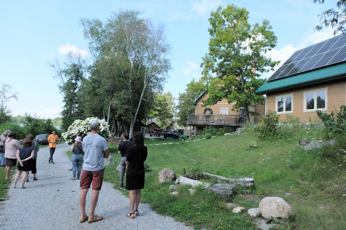 Jakob Wildfong of Lake Edge Cottages, a member of Green Economy Peterborough, conducts a tour of their resort property near Young's Point, which includes a 110-panel solar array installed in 2023. (Photo: Lili Paradi / GreenUP)