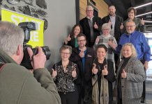 The inductees of JA-NEO's 2024 Business Hall of Fame give the thumbs-up to photographer Clifford Skarstedt at VentureNorth in downtown Peterborough on January 17, 2024. Pictured (left to right, front to back): Gwyneth James, Jeaninne Taylor, Cindy Koskowski on behalf of John Cunningham, Nicole Truman, Richard Labelle, Jill and Robert Staples, Mike and Andrew Winslow, and Cora Whittington. Not pictured are Tim Barrie, Chris Winslow, and Steve and Tom Gerolamy. (Photo: Bruce Head / kawarthaNOW)