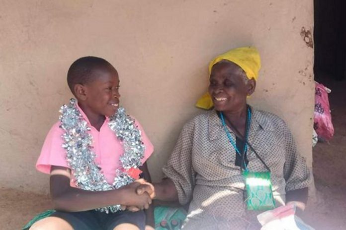 Kenyan farmer Naomy adopted Emmanuel when he was two years old and she was a teenager who was already struggling to feed her grandparents on the plot of farmland she rents. She was abandoned as a child and didn't want the same to happen to him. Pictured is Naomy's grandmother congratulating 10-year-old Emmanuel after he graduated from Grade 4. (Photo supplied by David McNab)