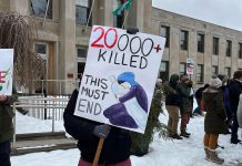 A sign held by a participant at a vigil for Palestine in front of Peterborough City Hall notes the number of Palestinian civilians killed as a result of the Israel-Hamas war. (Photo: Helen McCarthy)