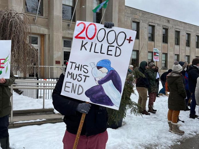 A sign held by a participant at a vigil for Palestine in front of Peterborough City Hall notes the number of Palestinian civilians killed as a result of the Israel-Hamas war. (Photo: Helen McCarthy)