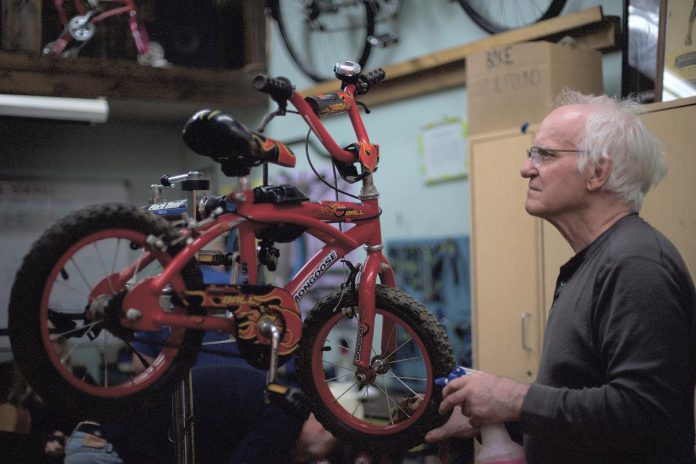 Volunteer John White works on a children's bike at B!KE - The Peterborough Community Bike Shop. The non-profit charitable organization is holding its annual Kids' Bike Build on April 14, 2024 and is seeking donations of used children's bikes that can be refurbished and given away to local organizations working with children and families. (Photo courtesy of B!KE)