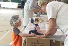 A child helps a volunteer pack meals during a past One Million Meals Peterborough event in support of Kids Against Hunger Canada. (Photo: One Million Meals Peterborough / Facebook)