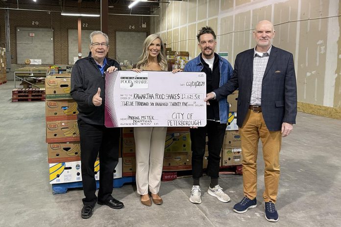 Peterborough mayor Jeff Leal, Kawartha Food Share general manager Ashlee Aitken, city councillor Alex Bierk, and Bill Wolfe of sponsor Wolfe Personal Injury Lawyers on February 7, 2024 Kawartha Food Share's warehouse at 665 Neal Drive with a cheque for $12,625.88 for Kawartha Food Share, representing proceeds donated during the city's two-hour free holiday parking promotion. Not pictured: city councillor Joy Lachica. (Photo: City of Peterborough)