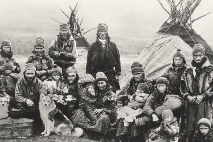Sámi people in the early 20th century in front of two lavvu tents, which are similar to a tepee but less vertical and more stable in high winds. The tents enabled the Sámi to follow their reindeer herds on the treeless plains of Sápmi, and are still used as a temporary shelter by the Sámi. (Public domain photo)