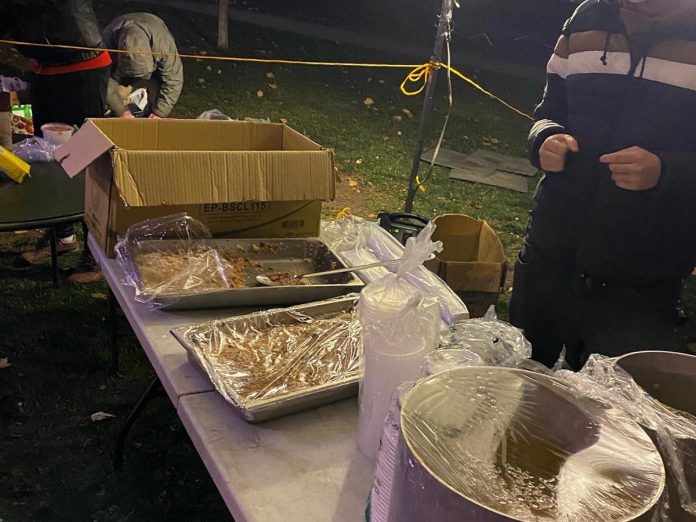 Volunteers with Food Not Bombs Peterborough serving a free meal at Confederation Square across from City Hall on November 14, 2022. In an emailed statement, Peterborough Mayor Jeff Leal confirmed the group now needs a permit to continue to use the park. (Photo: Myles Connor / Facebook)