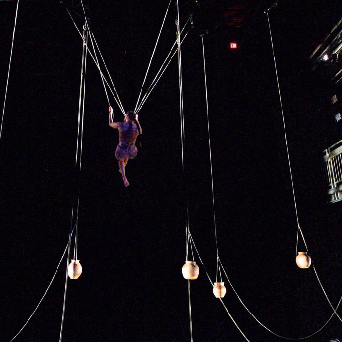 One of the most unusual aspects of Mexican-Canadian aerial and performance artist Diana Lopez Soto's "Nomada" is her use of numerous large clay pots called cantaros, which are filled with water, beans, corn, and soil and suspended around the stage, connected to each other and to Lopez Soto through a complex counterbalance system of ropes and pulleys. The vessels rise and fall in a choreographed vertical dance as Lopez Soto rises and falls with them, swinging dramatically from one side of the stage to the other. (Photo: Chris Randle)