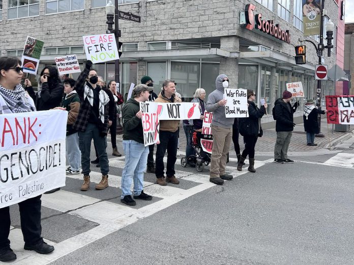 Around 50 protesters gathered at the Scotiabank branch at Hunter and Water streets in downtown Peterborough on March 15, 2024 to demand the bank's asset management arm fully divest its holdings in Elbit Systems Ltd., an Israeli defence contractor. (Photo: Nogojiwanong 2 Palestine)