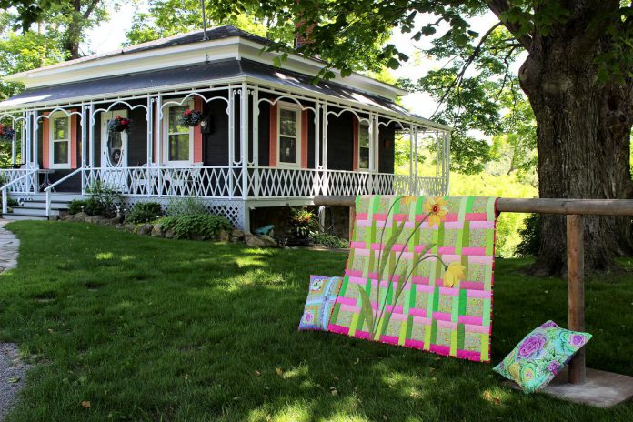 The Blocks and Blooms event on June 15, 2024 hosted by the Millbrook Cavan Historical Society is a self-guided tour where visitors can learn about historical properties in the area while enjoying abundant gardens and seeing a display of vibrant contemporary and heirloom quilts. Built in 1837, the Ontario or Regency Cottage at 3 Bank Street is likely the oldest surviving house in Millbrook. The preserved one-and-a-half-storey home is one of the heritage properties included in the tour. (Photo courtesy of Millbrook Cavan Historical Society)