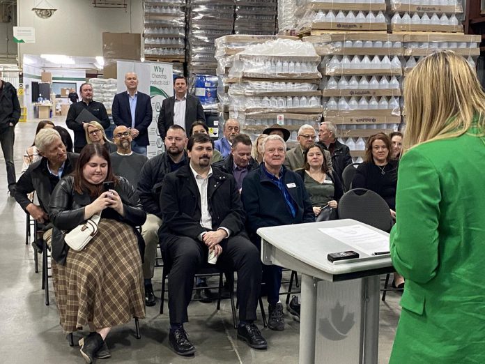 Community Futures Peterborough executive director Devon Girard spoke to a sizable audience during her opening remarks at Charlotte Products' Fisher Drive location on April 22, 2024, when she announced details of the non-profit economic development organization's new Climate Change and Environment Fund. (Photo: Paul Rellinger / kawarthaNOW)