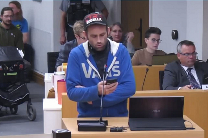 Food Not Bombs representative Ben Rempel reads a statement on behalf of the organization at the Peterborough city council meeting on April 8, 2024. (kawarthaNOW screenshot of City of Peterborough video)