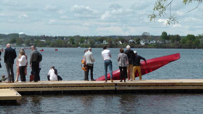 A canoeist putting in from one of the expansive seasonal docks that are part of the new Canadian Canoe Museum's lakefront campus during a grand opening celebration for the new museum on May 11, 2024. (Photo: Bruce Head / kawarthaNOW)