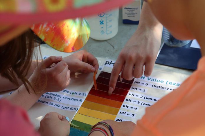 Students at the Peterborough Children's Water Festival perform tests on various everyday liquids to understand the concept of acidity and how changes in acidity can impact lake environments. (Photo: Jessica Todd)