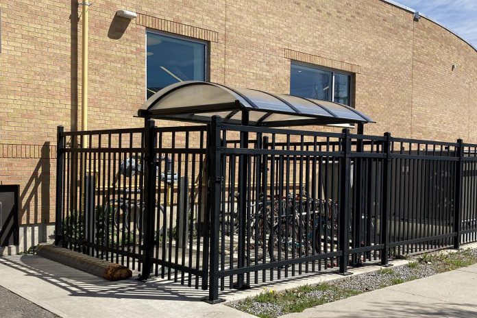 Peterborough Public Library staff are long-time participants in the Shifting Gears May Challenge and keen bike commuters. The library provides bike parking that features a roof to protect staff bikes from the elements and a secure fence to protect them from theft. (Photo: Jackie Donaldson)